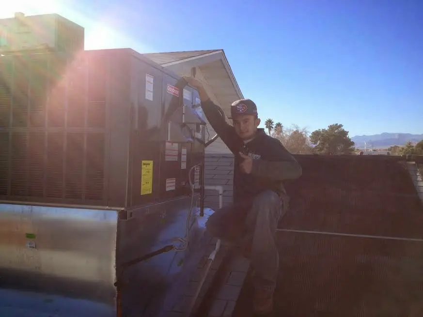 HVAC technician performing Air Duct Cleaning on a rooftop unit in Tarrytown